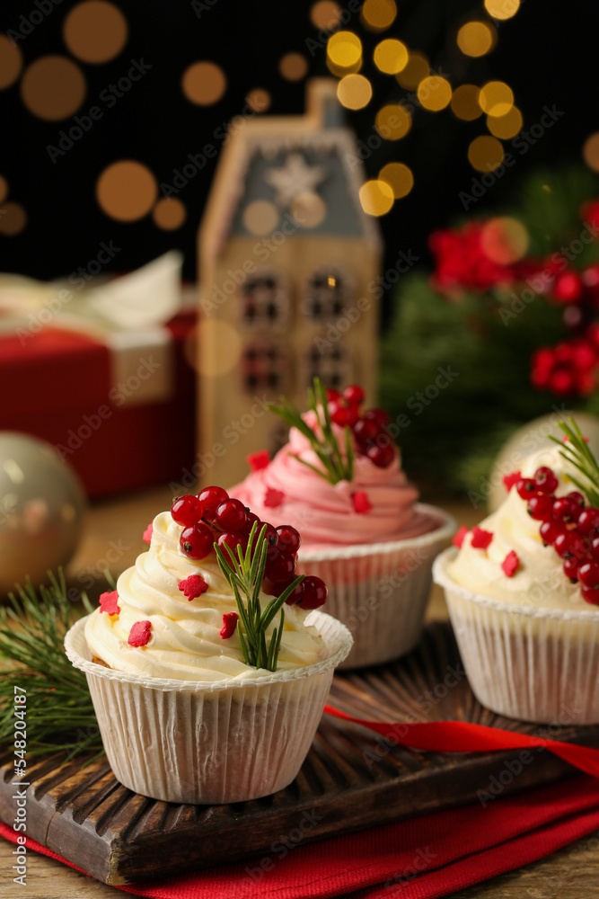 Delicious cupcakes and Christmas decorations on wooden table