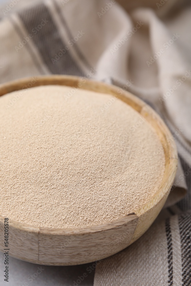 Granulated yeast in wooden bowl on table, closeup Granulated yeast in wooden bowl on table, closeup