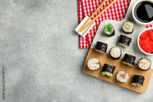 Flat lay composition with sushi rolls on grey table. Space for text