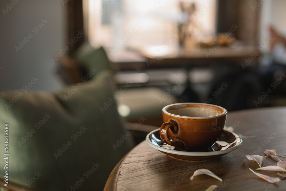 Stylish brown cup on wooden table. Cafe or restaurant concept. Copy space. Stylish brown cup on wooden table. Cafe or restaurant concept. Copy space.