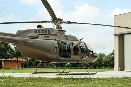 Billede på lærred Beautiful helicopter on helipad near white hangar