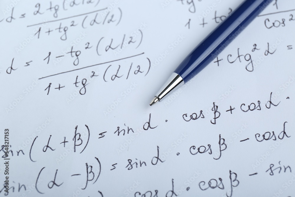 Sheet of paper with different mathematical formulas and pen, closeup Sheet of paper with different mathematical formulas and pen, closeup