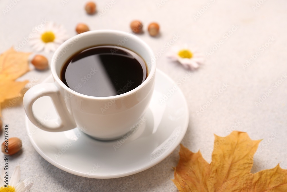 Composition with cup of hot drink and autumn leaves on light grey textured table, closeup