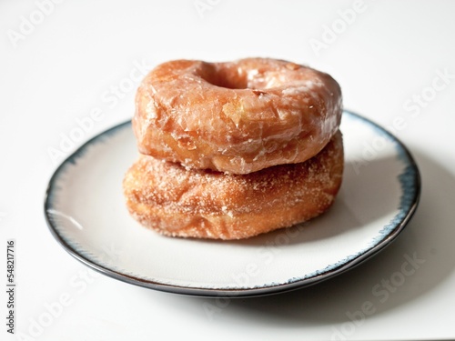 Closeup of delicious doughnuts on a plate against a white background
