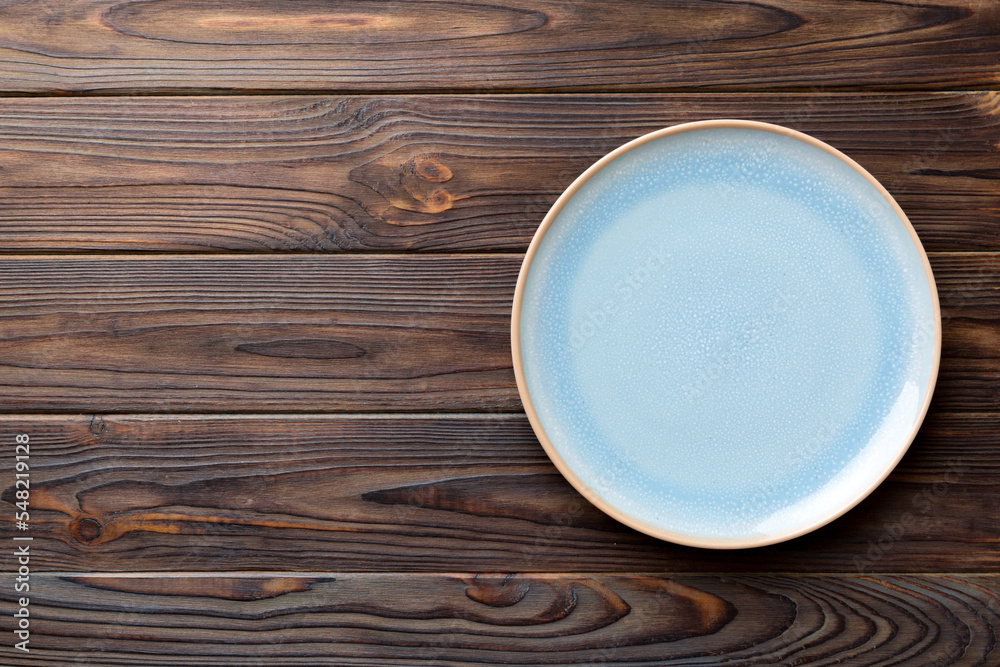 Top view of empty blue plate on wooden background. Empty space for your design Top view of empty blue plate on wooden background. Empty space for your design