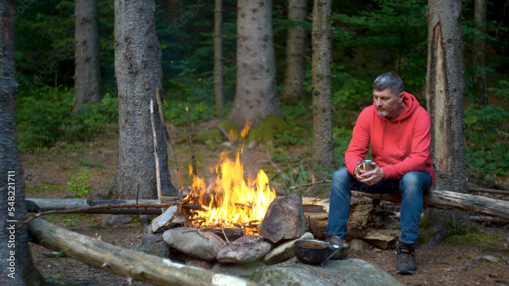 Bearded man near a fire in the mountains Bearded man near a fire in the mountains