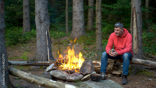 Bearded man near a fire in the mountains