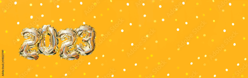 Helium golden balloon number of year 2023. Glowing festive garland with bokeh on orange background. Happy New Year banner Helium golden balloon number of year 2023. Glowing festive garland with bokeh on orange background. Happy New Year banner