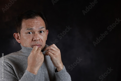 Middle-aged Japanese man in gray turtleneck wool sweater. Concept image of Warm Biz, stability in daily life, and sustainable living.