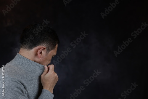 Middle-aged Japanese man in gray turtleneck wool sweater. Concept image of Warm Biz, stability in daily life, and sustainable living.