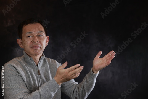 Middle-aged Japanese man in gray turtleneck wool sweater. Concept image of Warm Biz, stability in daily life, and sustainable living.