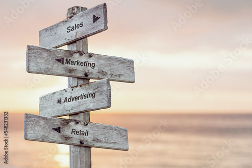 sales marketing advertising retail text written on wooden signpost outdoors at the beach during sunset