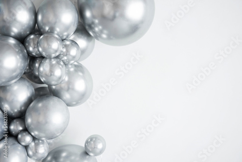Silver balloons on a white background with copy space.