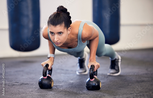 Exercise, kettlebell plank and woman focus on fitness, body transformation goals or health wellness. Workout motivation, sports challenge determination and athlete training on boxing gym floor