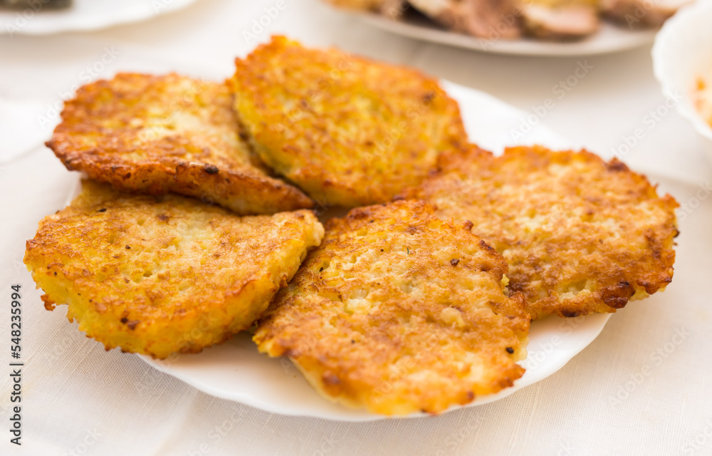 Potato pancakes with sour cream on white plate Potato pancakes with sour cream on white plate
