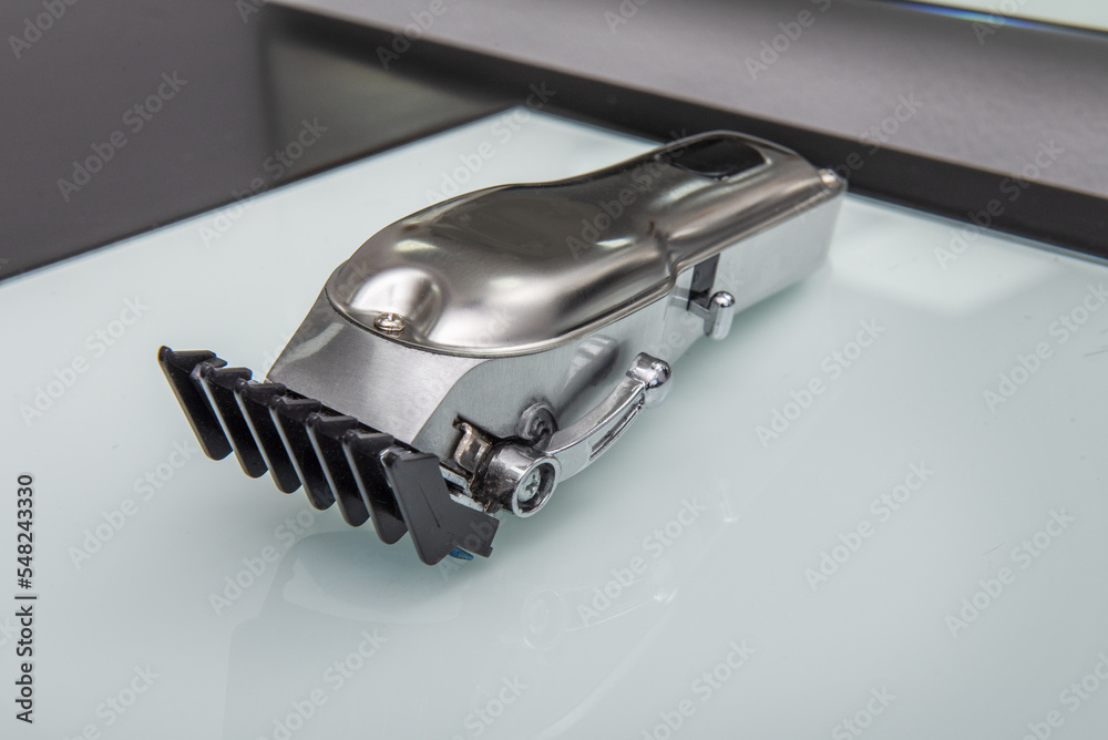 Metal hair clippers for men's barbershop on a smooth white surface Metal hair clippers for men's barbershop on a smooth white surface