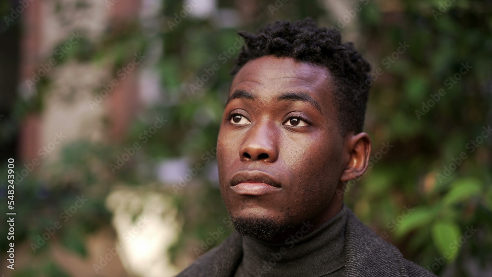Pensive young black African man standing outdoors Pensive young black African man standing outdoors