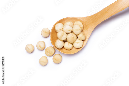 Macadamia nuts in wooden ladle isolated on white background. Top view. Flat lay.