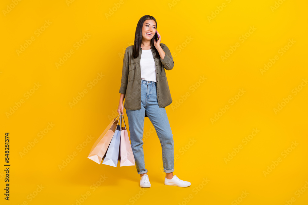 Full length photo of young excited popular star blogger speaking phone want order more black friday offers isolated on yellow color background