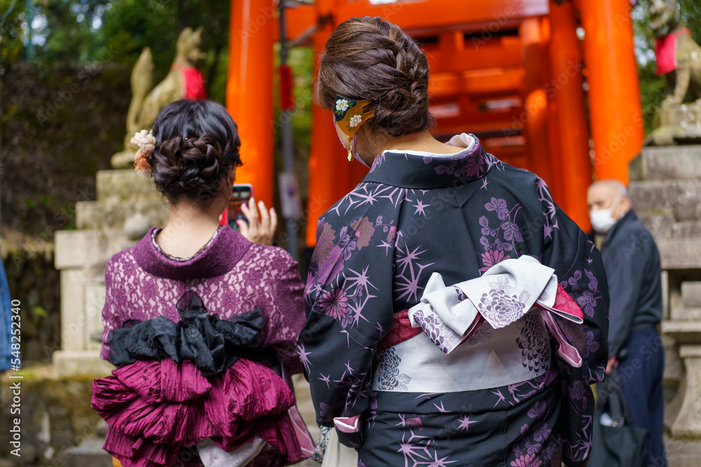 Fototapeta premium Young girl wearing Japanese kimono standing in Kyoto, Japan. Kimono is a Japanese traditional garment. The word