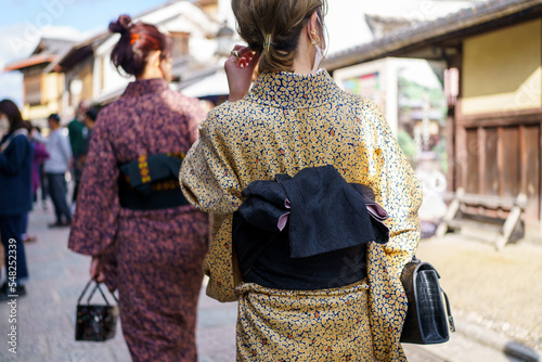 Young girl wearing Japanese kimono standing in Kyoto, Japan. Kimono is a Japanese traditional garment. The word "kimono", which actually means a "thing to wear"