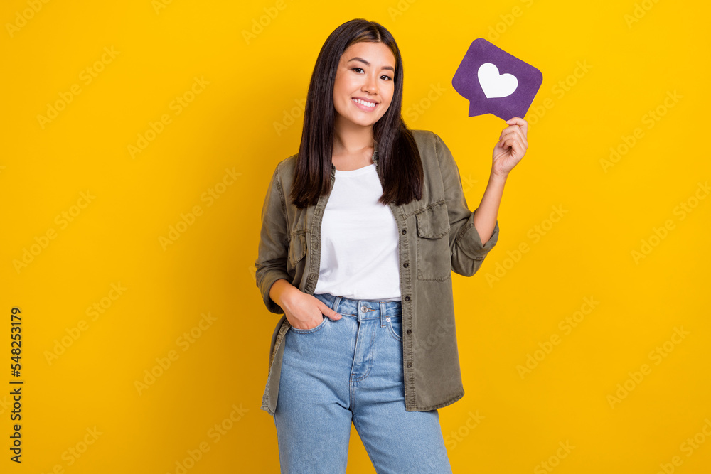 Photo of young confident successful model blogger wear trendy outfit hold paper purple like symbol share instagram isolated on yellow color background