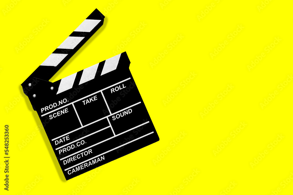 Movie clapperboard for shooting videos and movies on a yellow background copy space