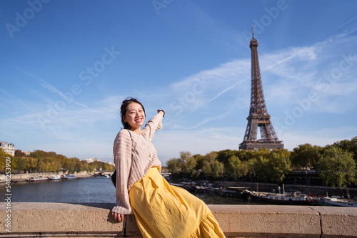 Happy female tourist on embankment in Paris
