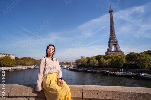 Happy female tourist on embankment in Paris photo