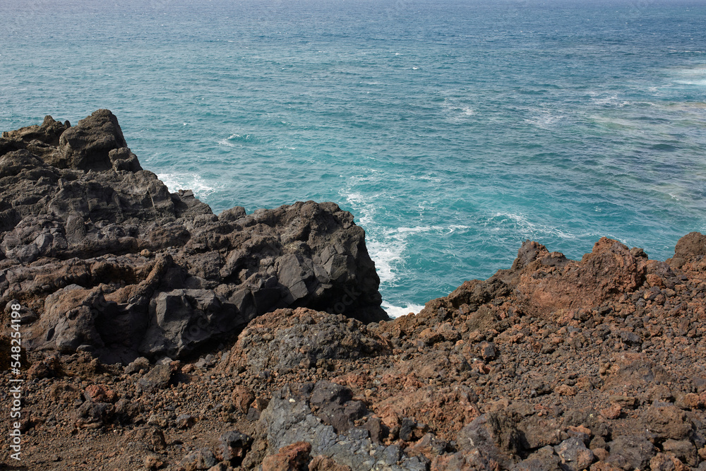 Scenic landscape of rocky cliff in foamy ocean in volcanic terrain Scenic landscape of rocky cliff in foamy ocean in volcanic terrain