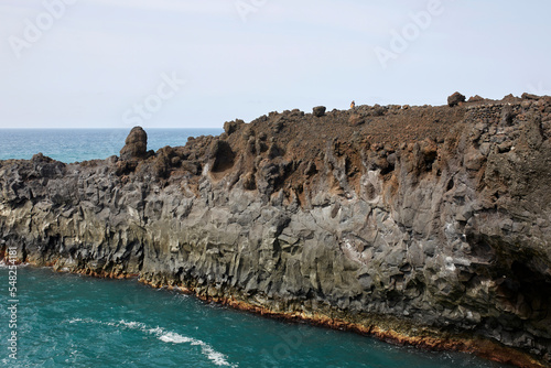Scenic landscape of rocky cliff in foamy ocean in volcanic terrain