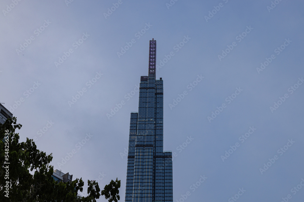 Obraz premium Ho Chi Minh City, Vietnam - November 08, 2022: Landmark 81, a building in Saigon. Landmark 81 among other high-rise buildings of Vinhomes Central Park urban area with a lawn and palm tree alley