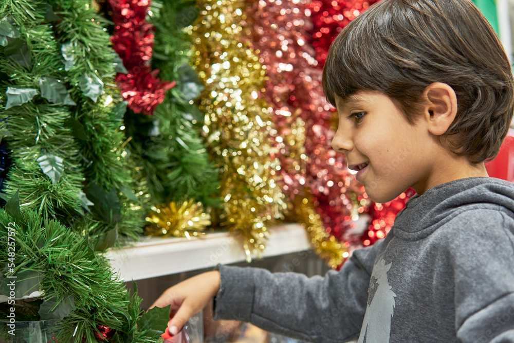 happy kid buying christmas decorations at the supermarket