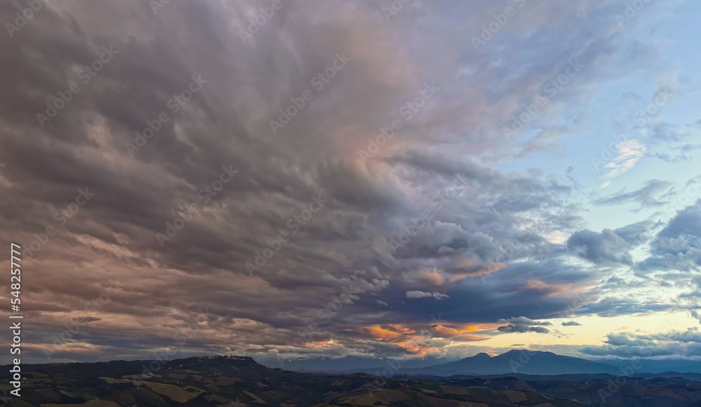 Nuvole enormi e colorate al tramonto sopra le montagne le colline e le valli degli Appennini
