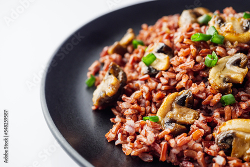 delicious red rice with mushrooms on a white background