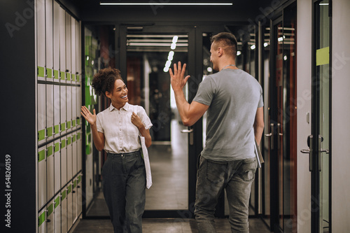 Joyful office worker saying hello to her coworker photo