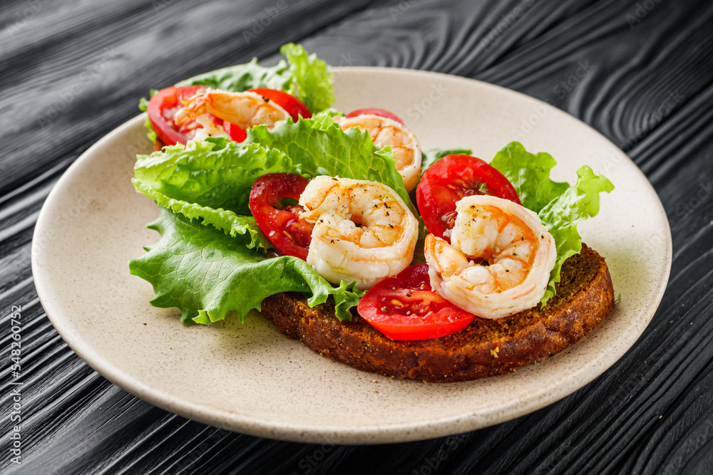 delicious Italian bruschetta with shrimps on a black wooden rustic background delicious Italian bruschetta with shrimps on a black wooden rustic background