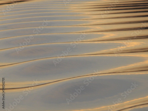 water forming beautiful pattern and reflecting evening sun light © Pooja