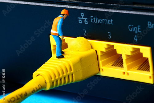 Conceptual image of miniature figure workmen investigating a fault on a broadband network cable