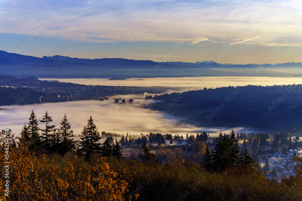 Upper floors of high-rise condominiums poking through Fall cloud inversion over Fraser Valley, BC, Canada
