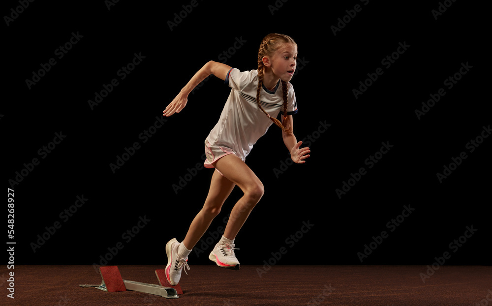 Focus on movement. Portrait of begginer athlete, runner training isolated on black studio background. Concept of action, motion, speed, healthy lifestyle.