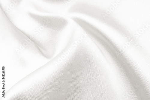 The texture of a fabric made of silk or calico with waves and rumples. Textile. Background of white material