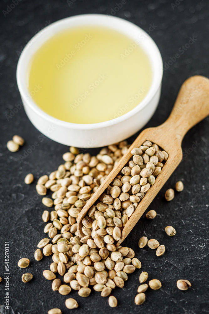 natural hemp seed essential oil on black stone background natural hemp seed essential oil on black stone background