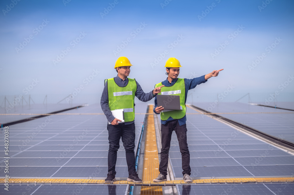 Team Asian Engineer checking solar power solar cell energy on rooftop of factory.Team Asian worker working install solar power solar cell energy system for using clean energy. Team Asian Engineer checking solar power solar cell energy on rooftop of factory.Team Asian worker working install solar power solar cell energy system for using clean energy.