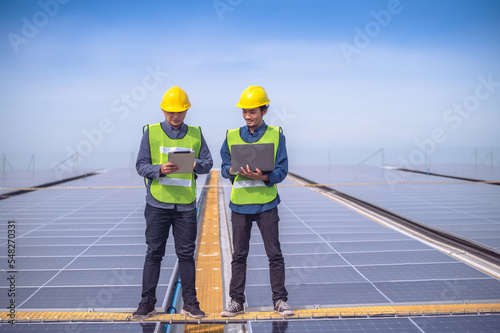 Wallpaper Mural Team Asian Engineer standing on rooftop factory and checking solar power solar cell energy by tablet technology. Torontodigital.ca
