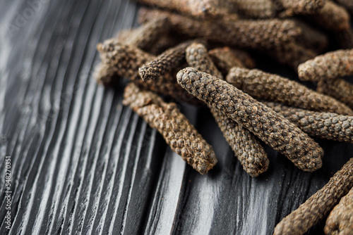 dried aromatic pippali long pepper on black wooden rustic background