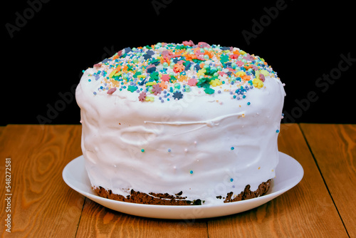 Homemade Easter cake. White glaze.bread pie  cake. decorated with sweets. on a rustic wooden background. with Easter red eggs. spring flowers. happy Easter.mea 