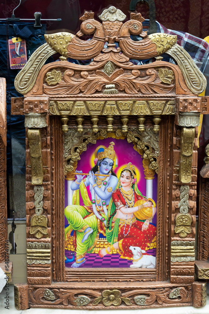 Obraz premium Beautiful framed art of Radha and Krishna, Hindu God, displayed for sale at famous Sardar Market and Ghanta ghar Clock tower in Jodhpur, Rajasthan, India.