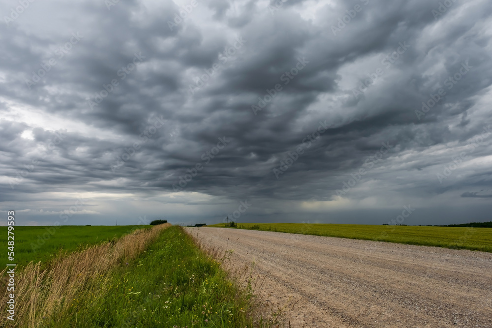 panorama of black sky background with storm clouds. thunder front over gravel road panorama of black sky background with storm clouds. thunder front over gravel road