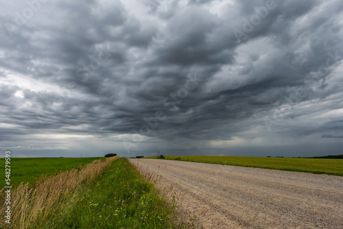 panorama of black sky background with storm clouds. thunder front over gravel road
